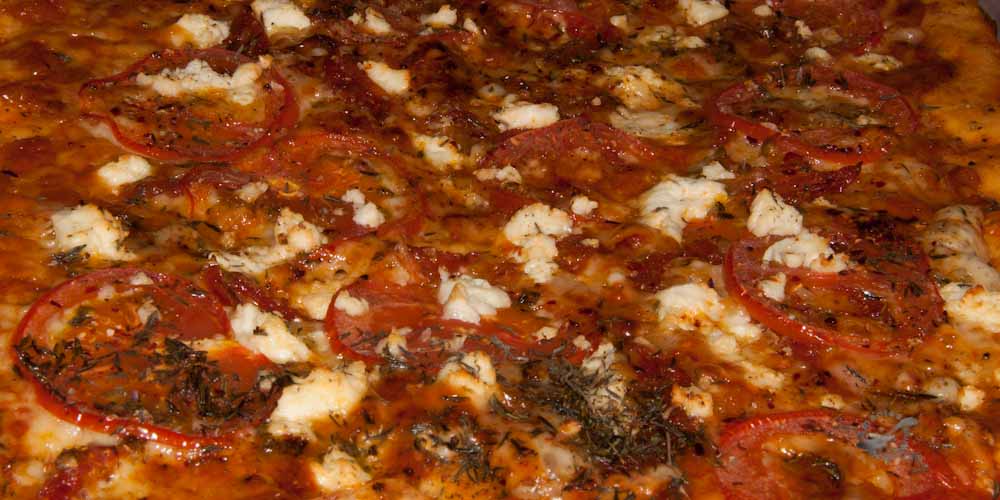 Pizza con tomates en tres variaciones y queso feta